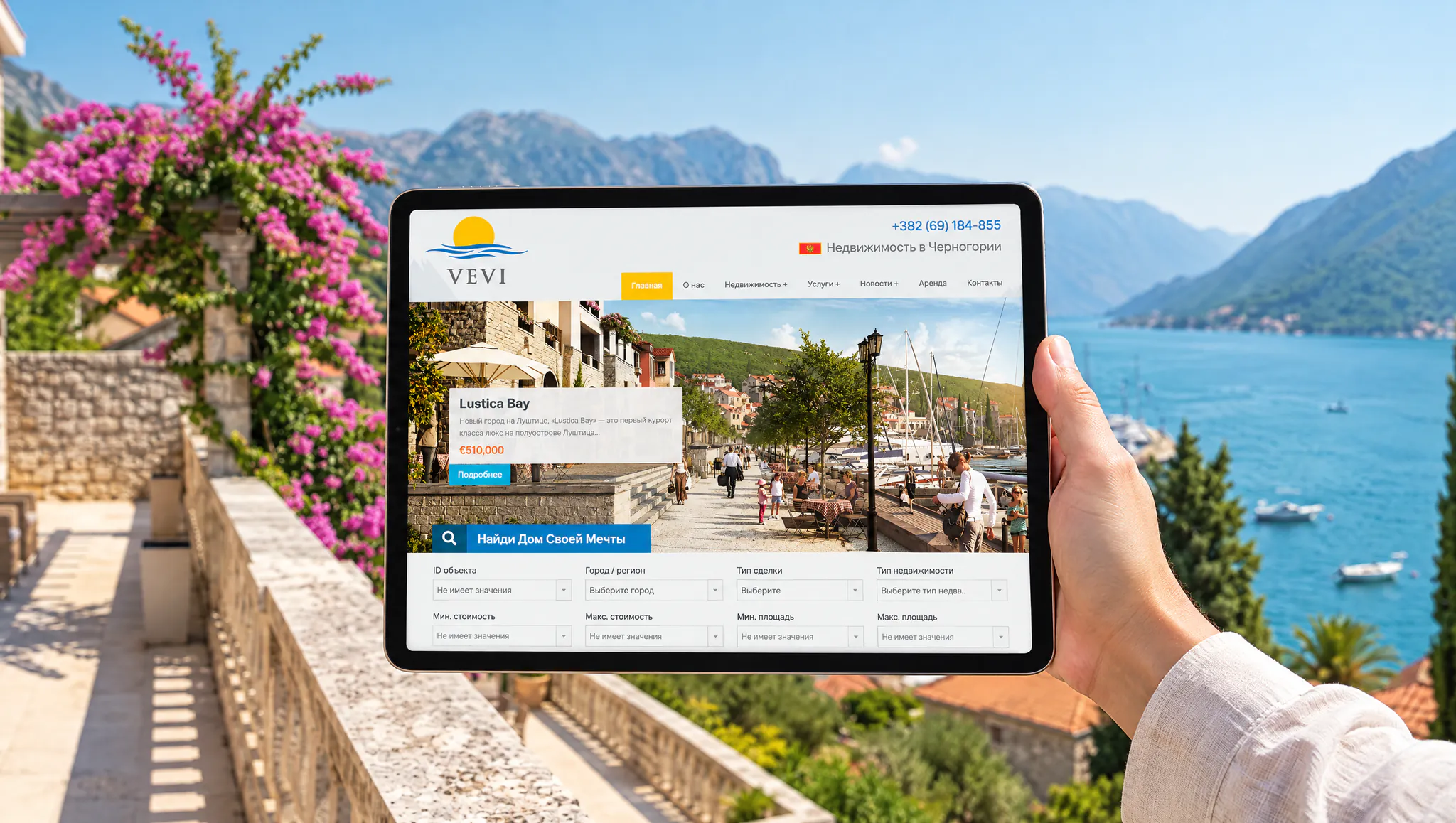 A tablet in hand with a real estate agency's home page on a terrace above a bay in Montenegro: cover of a case about a real estate website