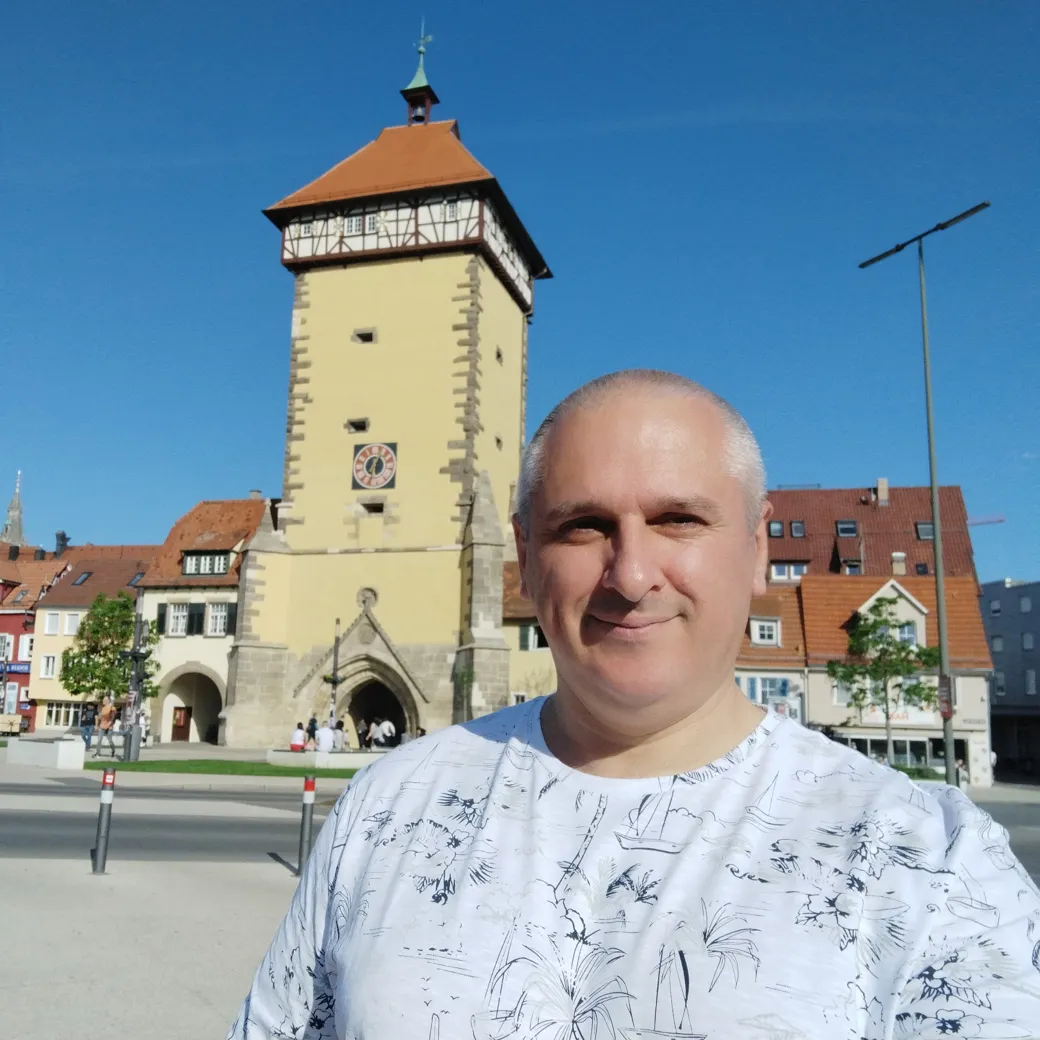 Sergey Raevsky next to a yellow clock tower